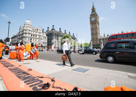 Demonstranten unterstützen Guantánamo-Häftling, Shaker Aamer in der Nähe von Westminster in London im Juli 2013 in Orange und schwarz gekleidet Stockfoto