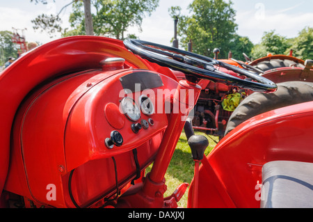 Lenkrad, Kontrollen und Steuersysteme auf einem roten Oldtimer-Traktor Stockfoto
