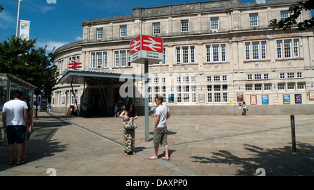 Einen jungen asiatischen Paar außerhalb Swansea Bahnhof Vorplatz unter biligual Walisischen Swansea Abertawe anmelden Glamorgan Wales UK KATHY DEWITT Stockfoto