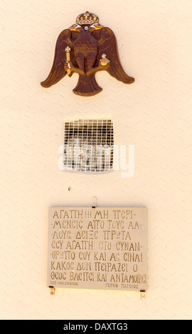 Wappen und griechischen religiöses Symbol, Plakette mit dem Namen auf der Mauer des Klosters in Kreta, Griechenland Stockfoto