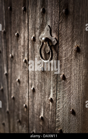 Nahaufnahme einer alten Holztür mit Metall-Nieten und Griff. Stockfoto
