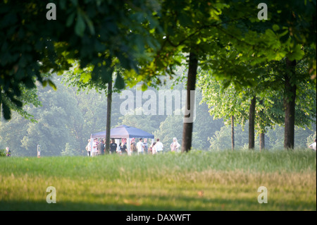 Gruppen von jungen Erwachsenen, die Geselligkeit Sommer Tag Kensington gardens Stockfoto