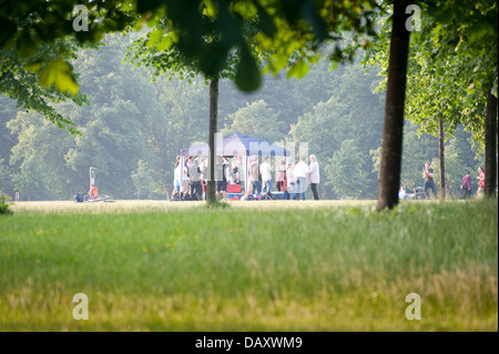 Gruppen von jungen Erwachsenen, die Geselligkeit Sommer Tag Kensington gardens Stockfoto