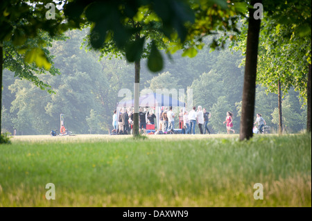 Gruppen von jungen Erwachsenen, die Geselligkeit Sommer Tag Kensington gardens Stockfoto