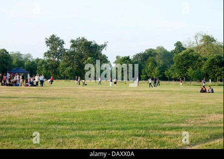 Gruppen von jungen Erwachsenen, die Geselligkeit Sommer Tag Kensington gardens Stockfoto