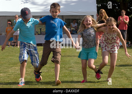 Jugendliche, die an einem 2-beinigen Rennen bei worldham Dorffest, Hampshire, uk. Sonntag, den 14. Juli 2013. Stockfoto