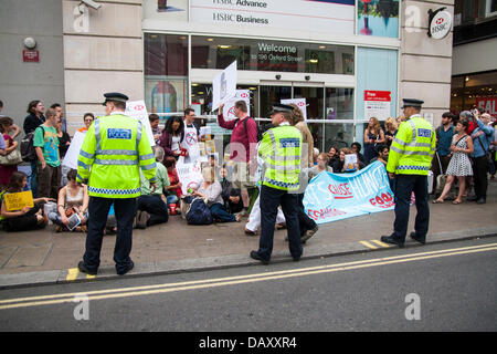 London, UK. 20. Juli 2013. Polizei halten Wache, wie UK Uncut halten Demonstrationen vor zwei London Niederlassungen der HSBC in Protest gegen was sie ist Steuer ausweichen von der Bank sagen als Laufwerk mehr Menschen Vertrauen auf Foodbanks Sozialabbau. Bildnachweis: Paul Davey/Alamy Live-Nachrichten Stockfoto