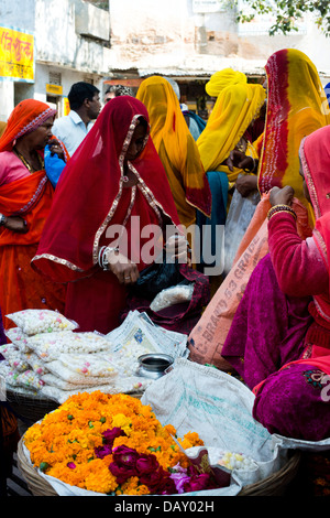 Frauen kaufen Prasada (religiöse Angebote) von einem Markt Abwürgen, Pushkar, Ajmer, Rajasthan, Indien Stockfoto