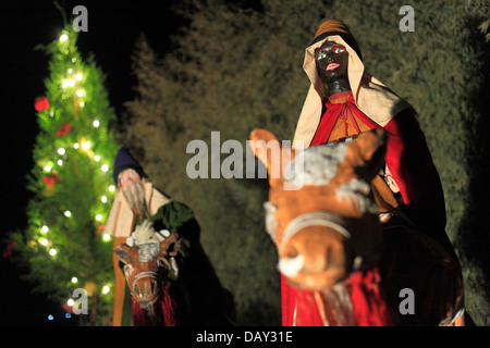 Weisen, die Reisen auf Kamelen in der Nacht mit einem Weihnachtsbaum im Hintergrund Stockfoto