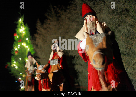 Three Wise Men Reisen auf Kamelen in der Nacht mit einem Weihnachtsbaum im Hintergrund Stockfoto