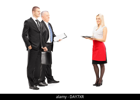 In voller Länge Portrait von einem lächelnden blonden Kellnerin mit Tablett servieren zwei Geschäftsleute Stockfoto