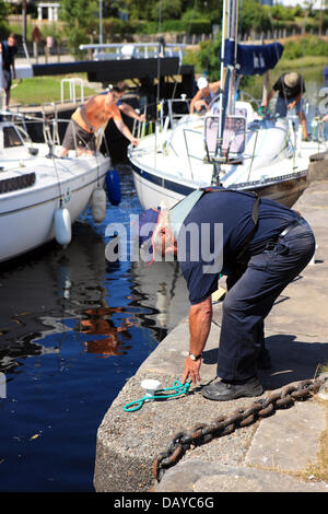 Crinan Canal, UK. 20. Juli 2013. Schleusenwärter bindet Yachten an eines der Schlösser auf den Crinan Canal bei Ardrishaig an einem heißen Nachmittag während der aktuellen Hitzewelle Credit: PictureScotland/Alamy Live News Stockfoto