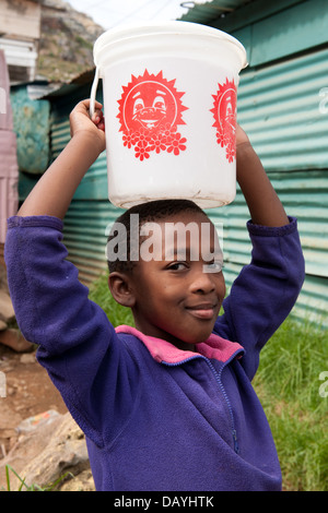 Mädchen tragen Wasser, Township Imizamo Yethu, Hout Bay, Kapstadt, Südafrika Stockfoto