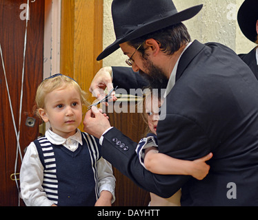 Ein 3 Jahre Alter religiösen jüdischer jungen immer seinen ersten Haarschnitt bei einem Ritual namens ein Upsherinish Stockfoto