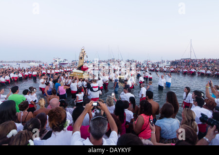 Nicht identifizierte lokale Anbeter heben eine religiöse Bild am Strand während des Festivals der Virgen del Carmen Stockfoto