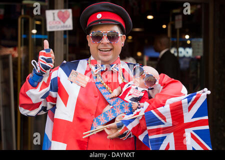 London, UK. 21. Juli 2013. Da das warten auf das Baby von der Herzogin von Cambridge weiter, stellt Darsteller Daniel Obando (The Cool Guy) vor dem "Cool Britannia" Geschäft am Piccadilly Circus, London, mit einer Babypuppe gekleidet in Anschluß-Markierungsfahne. Foto: Nick Savage/Alamy Live-Nachrichten Stockfoto