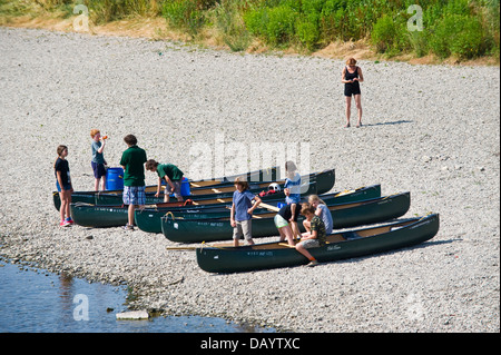 Gruppen der Kinder erhalten Unterricht in offenen Kanus am Ufer neben Fluss Wye bei Glasbury Powys Wales UK paddeln Stockfoto