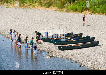 Gruppen der Kinder erhalten Unterricht in offenen Kanus am Ufer neben Fluss Wye bei Glasbury Powys Wales UK paddeln Stockfoto