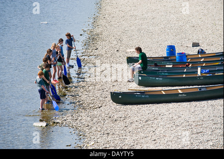 Gruppen der Kinder erhalten Unterricht in offenen Kanus am Ufer neben Fluss Wye bei Glasbury Powys Wales UK paddeln Stockfoto