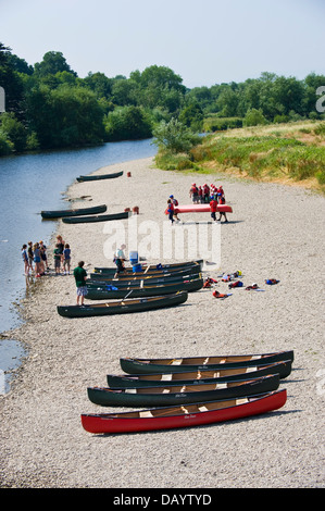 Gruppen der Kinder erhalten Unterricht in offenen Kanus am Ufer neben Fluss Wye bei Glasbury Powys Wales UK paddeln Stockfoto