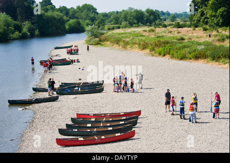 Gruppen der Kinder erhalten Unterricht in offenen Kanus am Ufer neben Fluss Wye bei Glasbury Powys Wales UK paddeln Stockfoto