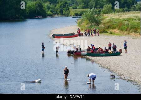 Gruppen der Kinder erhalten Unterricht in offenen Kanus am Ufer neben Fluss Wye bei Glasbury Powys Wales UK paddeln Stockfoto