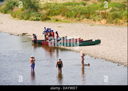 Gruppen der Kinder erhalten Unterricht in offenen Kanus am Ufer neben Fluss Wye bei Glasbury Powys Wales UK paddeln Stockfoto