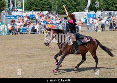 Glasgow, Schottland, 21. Juli 2013. Zwölf-Jahr-alten Skye Woodward, der jüngste Trick & Stunt-Fahrer in Großbritannien, mit dem lodernden Sättel-Stunt-Team bei der Glasgow Show 2013 auf Glasgow Green durchführen. Alles, was die Pferde vom Team sind gerettet Pferde. Stockfoto