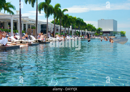 Gäste des Marina Bay Sands genießen ein Bad im Infinity-Pool des Hotels auf dem Dach und an den Sehenswürdigkeiten von Singapur Stockfoto