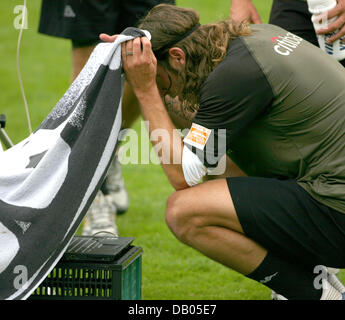 Werder Bremen-Spieler Torsten Frings blickt auf einen Laptop, geschützt durch ein Handtuch nach Laktat-test im ersten Training des Vereins der Bundesliga-Saison 2007/2008 in Bremen, Deutschland, 2. Juli 2007. Das Team ging nach seiner Trainingslager auf Norderney Insel nach der Sitzung. Foto: Carmen Jaspersen Stockfoto