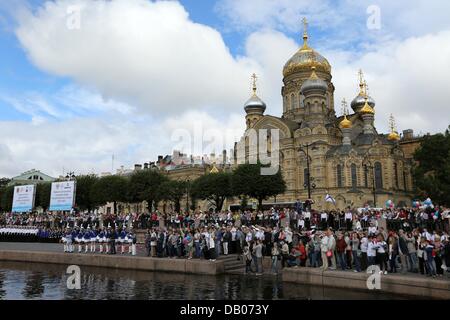 St. Petersburg, Russland. 20. Juli 2013. Verwandten warten geduldig am Ufer des Flusses Newa kennenlernen der Segler als Vintage russischen Fischerboot Sedov kehrt nach Hause zurück nach St. Petersburg nach Abschluss seiner ersten Weltumrundung in seiner 92 jährigen Geschichte. Die Viermastbark "Sedov", Baujahr 1921, segelte von St. Petersburg 20. Mai 2012 auf ihre Round-the-World-Reise beginnen. Für ein Jahr und zwei Monate ist die größte pädagogische Segelschiff der Welt (Guinness World Record) mehr als 47.000 Seemeilen, 34 Häfen in 24 Ländern andocken und überqueren die e gereist. Stockfoto