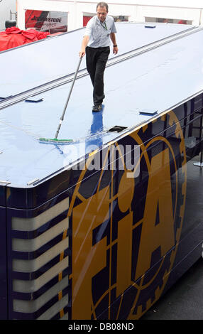 Ein Arbeiter wischt Wasser vom Dach einer ein FIA Truck im Fahrerlager der Rennstrecke Nürburgring, Deutschland, 19. Juli 2007. Die Formel 1 Grand Prix von Europa wird hier am Sonntag 22. Juli stattfinden. Foto: JENS Büttner Stockfoto