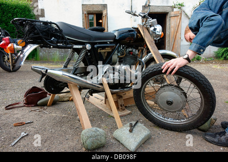 Reparatur von alten Motorrad mit hausgemachten Stand Mann Stockfoto