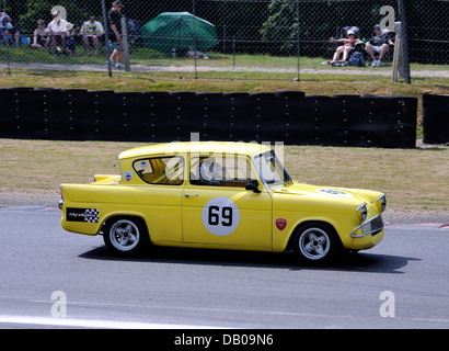 Gelbe alte Ford Anglia racing auf der Rennstrecke Stockfoto