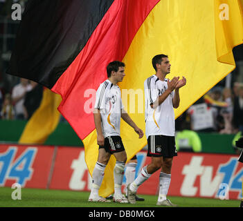 Deutsche Spieler Patrick Helmes (L) und Manuel Friedrich feiern auf dem Spielfeld vor einer großen deutschen Nationalflagge nach Fußball freundlich Deutschland Vs Rumänien im RheinEnergie-Stadion in Köln, Deutschland, 12. September 2007. Deutschland gewann 3:1. Foto: Achim Scheidemann Stockfoto