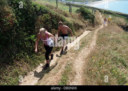 Teilnehmer Familien laufen auf dem Pembrokeshire Coast Path beim jährlichen Whitesands Triathlon Rennen auf St. David's Head Wales UK KATHY DEWITT Stockfoto