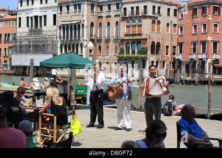 Straßenmusikanten spielen an Restaurants in Venedig Stockfoto