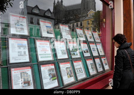 Eine Frau studiert die Angebote in einem Immobilienbüro in Cobh (County Cork), Hafen an der Küste von Irland, 14. Juni 2013. Stockfoto