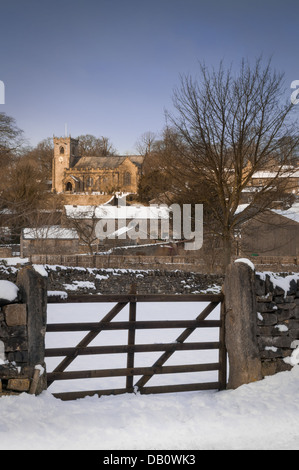 Das schöne Dorf Downham, Lancashire. Hier eingefangen, bedeckt mit Schnee und die letzten Strahlen der Sonne beleuchten die Kirche Stockfoto