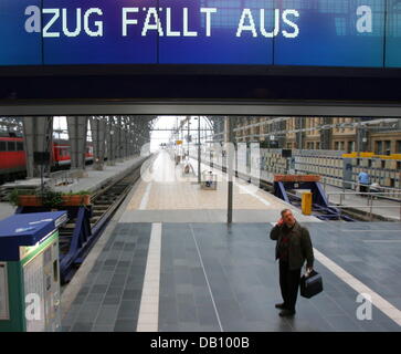 Ein Bahn-Reisender sieht sich um eine einsame Spur am Hauptbahnhof in Frankfurt Main, Deutschland, 12. Oktober 2007. Der Streik, forderte von der Deutschen Bahn Lokführer Union GDL ("Gewerkschaft der Lokomotivfuehrer"), begann früh und wird weiterhin Kurzstrecken-Verkehr in großen Teilen Deutschlands im Laufe des Tages zu lähmen. Der Streik wird geglaubt, um Einfluss auf Stockfoto