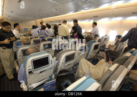 Passagiere sitzen in dem Hauptdeck der Singapore Airlines Airbus A380 Economy Class während seinen ersten kommerziellen Flug von Singapur nach Sydney, 25. Oktober 2007. Singapur ist die erste Fluggesellschaft den Superjumbo in seinen regelmäßigen Service zu integrieren. Der Airbus A380 wird wöchentlich zwischen Singapur und Sydney verwendet werden. Der Airbus A380 ersetzt Jumbojet Boeing 747 als größte Stockfoto