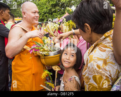 Phra Phutthabat, Saraburi, Thailand. 22. Juli 2013. Ein Mönch erhält Blumen von der Masse während der Tak Bat Dok Mai am Wat Phra Phutthabat in Saraburi Provinz von Thailand, Montag, den 22. Juli. Wat Phra Phutthabat ist berühmt für die Art und Weise, die es markiert den Beginn der Vassa, der drei-Monats-Klausurtagung von Theravada Mönche und Nonnen beobachtet. Der Tempel ist in Thailand hoch verehrt, weil es einen Schritt des Buddha beherbergt. Am ersten Tag der Vassa (oder buddhistischen Fastenzeit) Menschen kommen Sie zum Tempel '' machen Verdienst '' und die Mönche dort mit Tanz Dame Ingwer Blumen, die blühen nur in das, was wir präsentieren Stockfoto