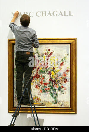 Ein Mann setzt den Namen des Malers Marc Chagall über seine Arbeit "Bouquet de Fleurs et Pflaumen (1969) am Stand der Frankfurter Galerie"Sterben Galerie"auf der Cologne Fine Arts Messe in Köln, 30. Oktober 2007. Einige 160 Galeristen, Kunsthändler und Antiquitätenhändler werden Objekte in der Kunst Handel fair statt vom 31. Oktober bis 4. November 2007 in Colo ausstellen. Stockfoto