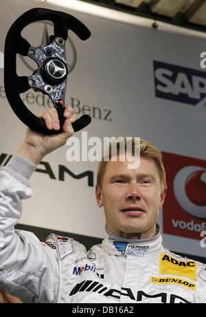 Zweifachen Formel 1 Weltmeister Mika Haekkinen präsentiert das Lenkrad seines letzten F1 Rennwagen bei der Mercedes-Benz Motorsport-Veranstaltung "Stars & Cars" in Stuttgart, Deutschland, 3. November 2007. 39-j hrige finnische Rennfahrer, der in letzter Zeit für Mercedes in der Deutschen Tourenwagen Masters DTM begann, erklärte seinen Rücktritt vom aktiven Motorsport. Foto: Marijan Murat Stockfoto