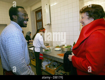 French Health Minister Roselyne Bachelot-Narquin (R) spricht mit Erick aus Benin während ihres Besuchs in das Integrationsprojekt "Weltkueche" ("World Kitchen") auf "Kaffee Graefe" in Berlin, Deutschland, 12. November 2007 kochen. "World Kitchen" entwickelte sich aus einer internationalen Unterstützungsgruppe für und durch HIV positiven Personen. Ziel ist es, die Integration von Migranten zu unterstützen. Die französischen Preside Stockfoto