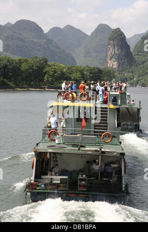 (Dpa-Datei) Die Datei Bild vom 3. Juli 2006 zeigt Ausflugsschiffe auf der vier-Stunden-Tour auf dem Li-Fluss von Guilin nach Yangshou, China. Die 83-Kilometer-Tour führt durch das berühmte Gebirge mit seinen steilen Klippen, Höhlen und die typische bizarre Kreide Hügel im Südwesten Chinas. Die einzigartige Landschaft zieht jedes Jahr Millionen von Touristen aus China und dem Ausland an Stockfoto