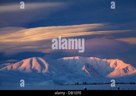 Alpenglühen am Hawkdun Range und linsenförmige Wolken, Maniototo, Central Otago, Südinsel, Neuseeland Stockfoto