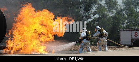 Senior Airman Larry Thompson und Flieger 1. Klasse Nathan Smalkoski Schlacht ein Flugzeug Feuer während einer Übung im Volk Field, Wisconsin, USA, Juli 17. Das Training war Teil des Patriot ausüben 2013 eine Nationalgarde inländischen Antwort-Übung, die beide enthalten Stockfoto