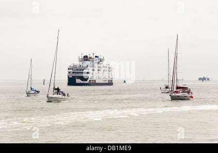 Eine Fähre Isle Of Wight und Segelboote übergeben im Hafen von Portsmouth, UK. Stockfoto