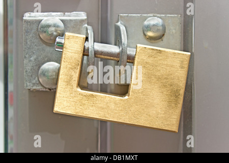 Geschlossenes Vorhängeschloss auf einer Metalltür Stockfoto